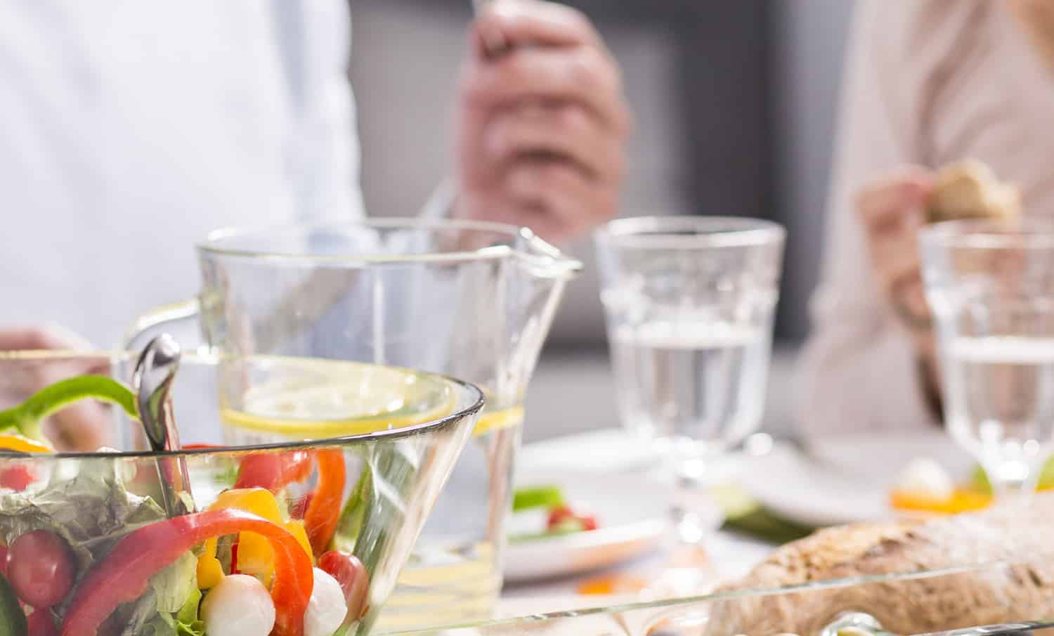 Close up of glasses and a food bowl at a table setting